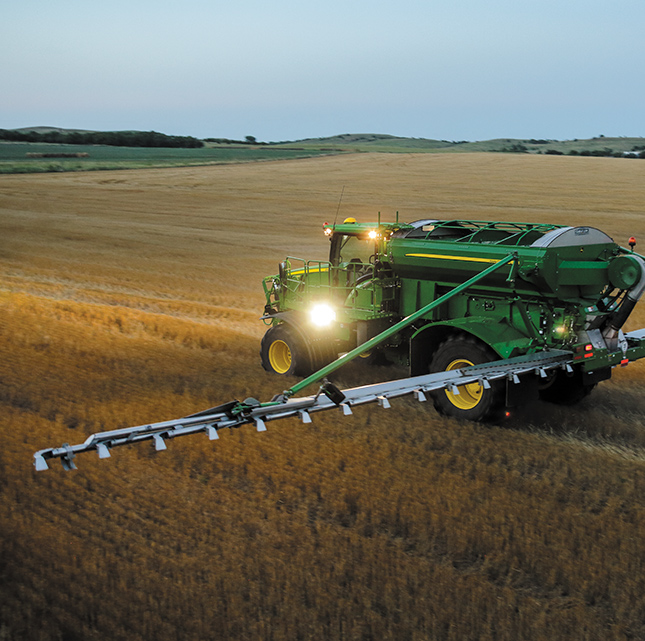 John Deere farmer in field spreading fertizilizer